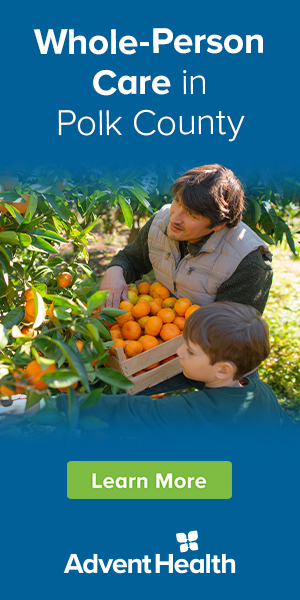 Man picks oranges with his son.
